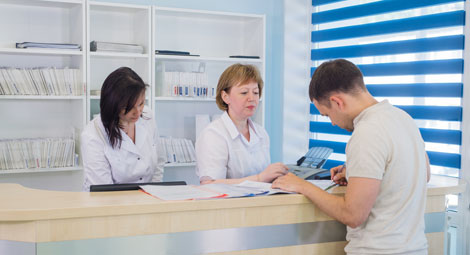 A man completing some paperwork at a reception desk